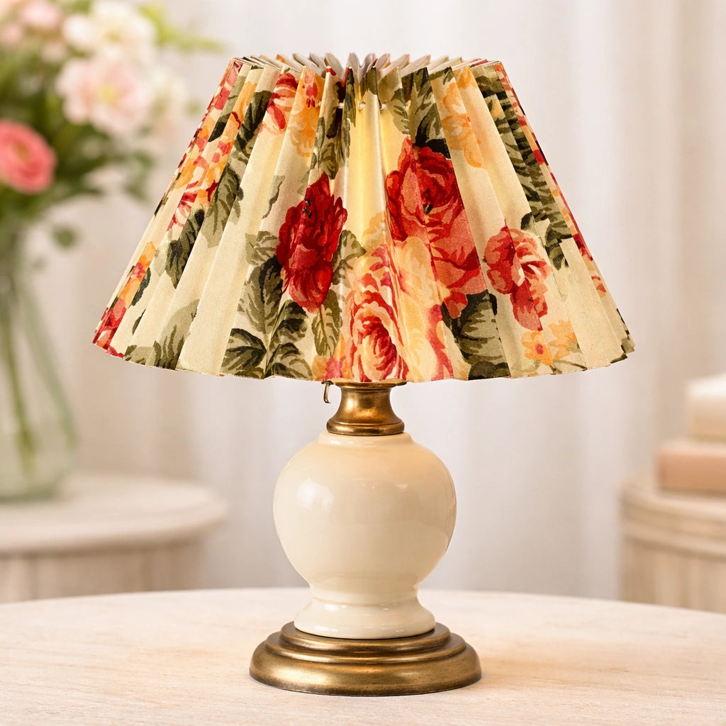 Plissierter Lampenschirm mit Blumenmuster in Creme-Weiß auf einer kleinen Tischlampe