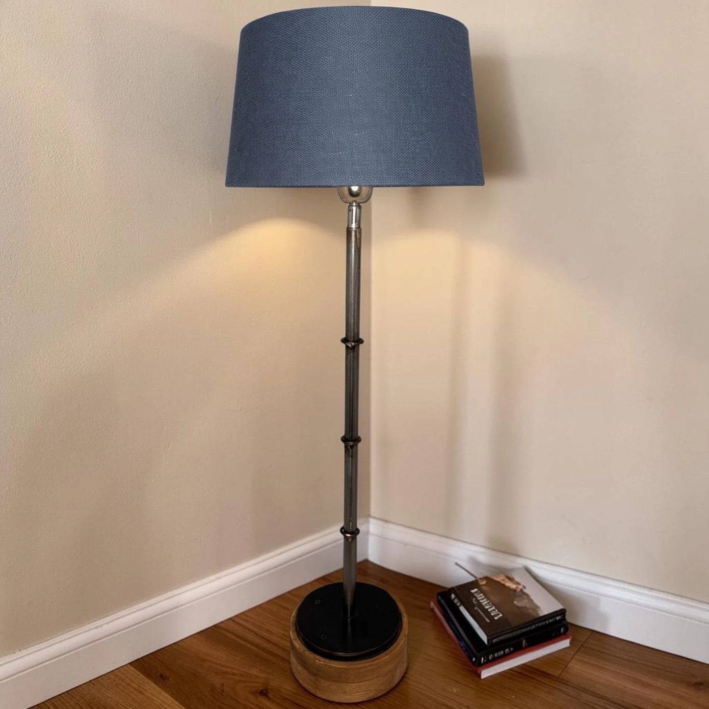 Blauer konischer Lampenschirm auf einer Stehlampe im Wohnraum