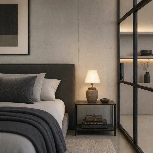 Stilvolle Nachttischlampe mit hellem Stoffschirm in modernem Schlafzimmer mit warmem Licht