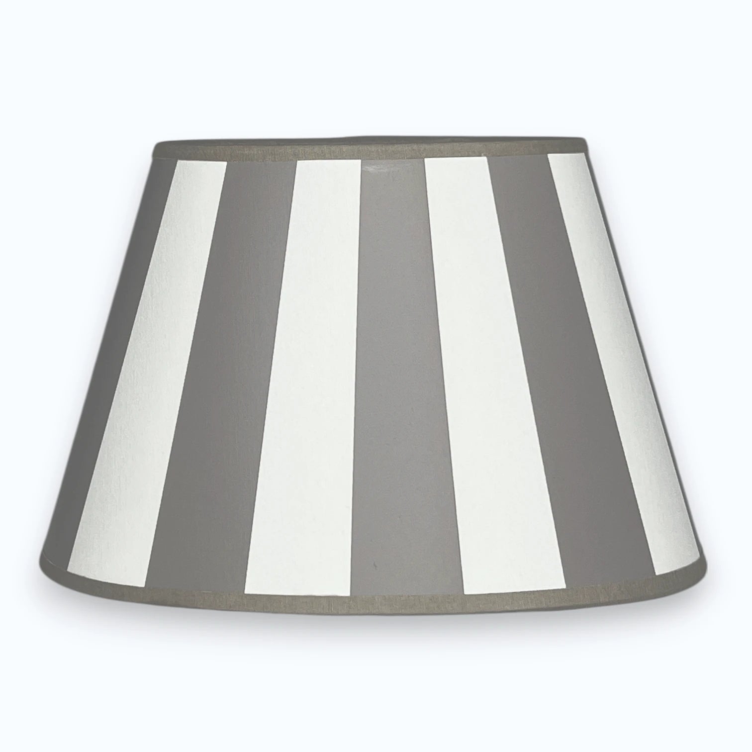 Ovaler Lampenschirm aus Stoff in Taupe und Weiß mit Streifendesign  auf hellem Hintergrund.