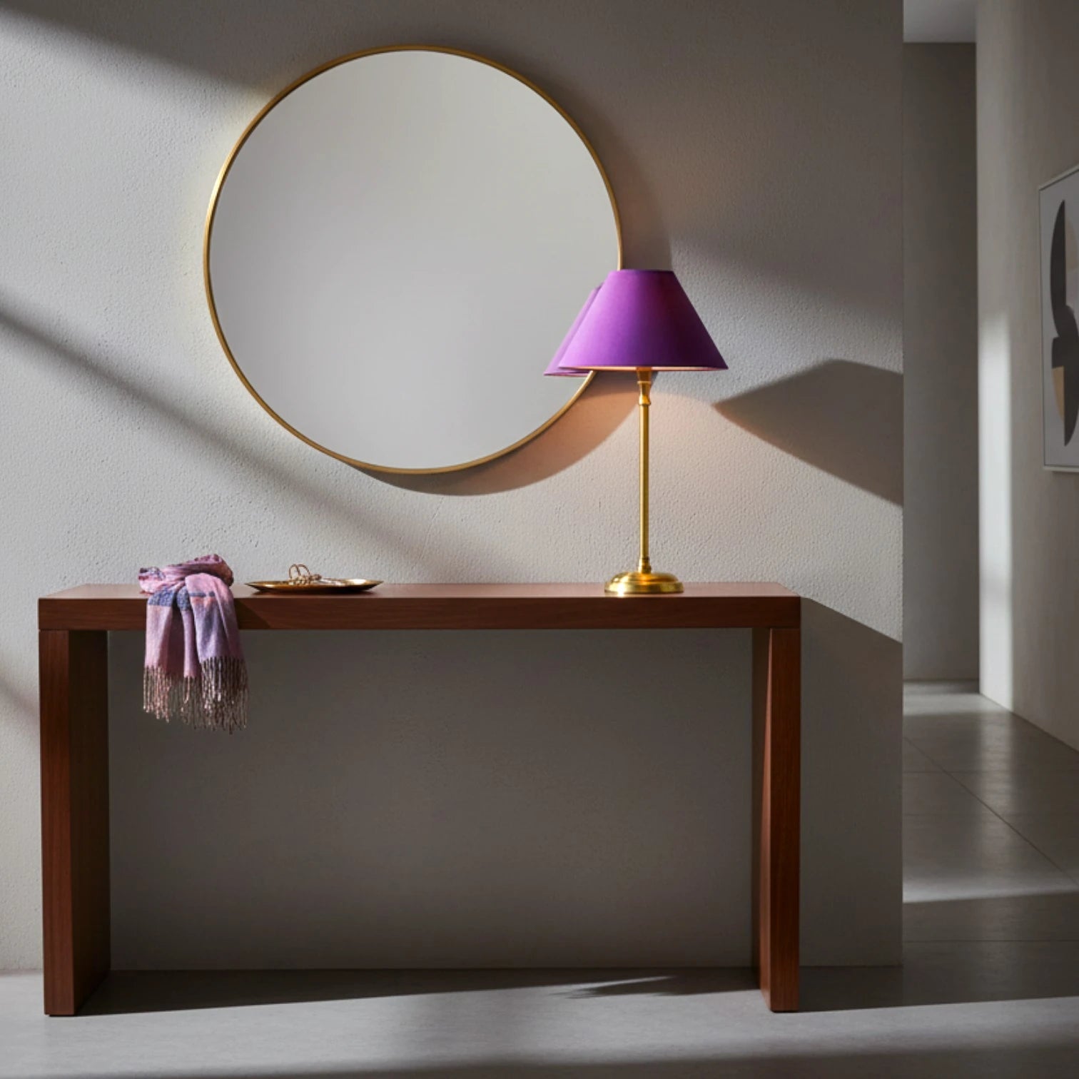 Lampenschirm in Violett auf einer Tischlampe mit schlankem goldfarbenem Fuß auf einem Holztisch in ein Modernen Flur.
