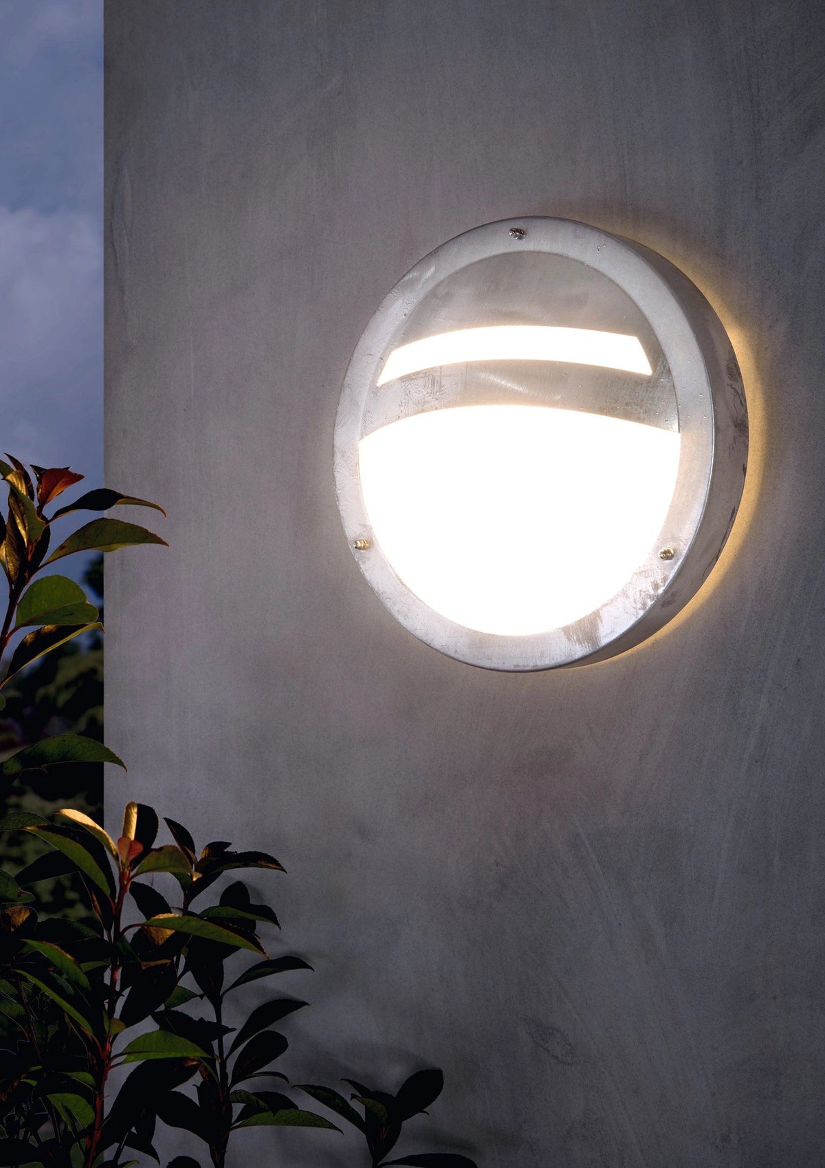 leuchtende runde flache außenwandlampe aus verziinkten stahl warmweiß leuchtend an außenwand - eglo sevilla 1