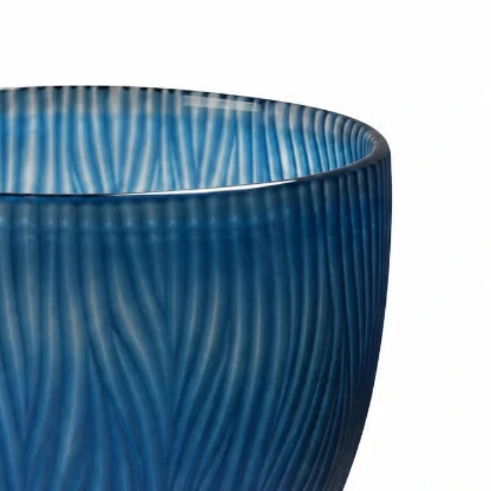 Detailaufnahme der blauen Glasvase von Sompex mit handgeschliffenem Wellenmuster auf weißem Hintergrund