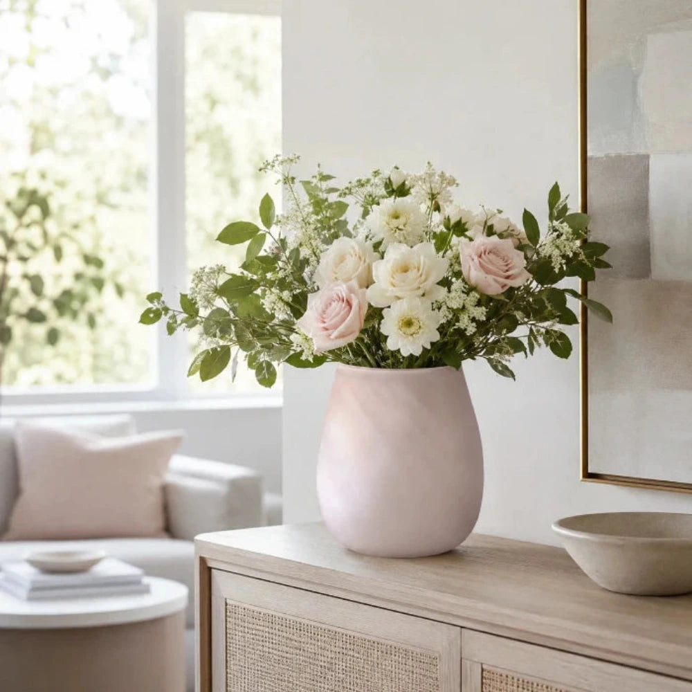 Elsa Glasvase in Pastell Rosa mit frischem Blumenstrauß auf einem modernen Sideboard im Wohnzimmer