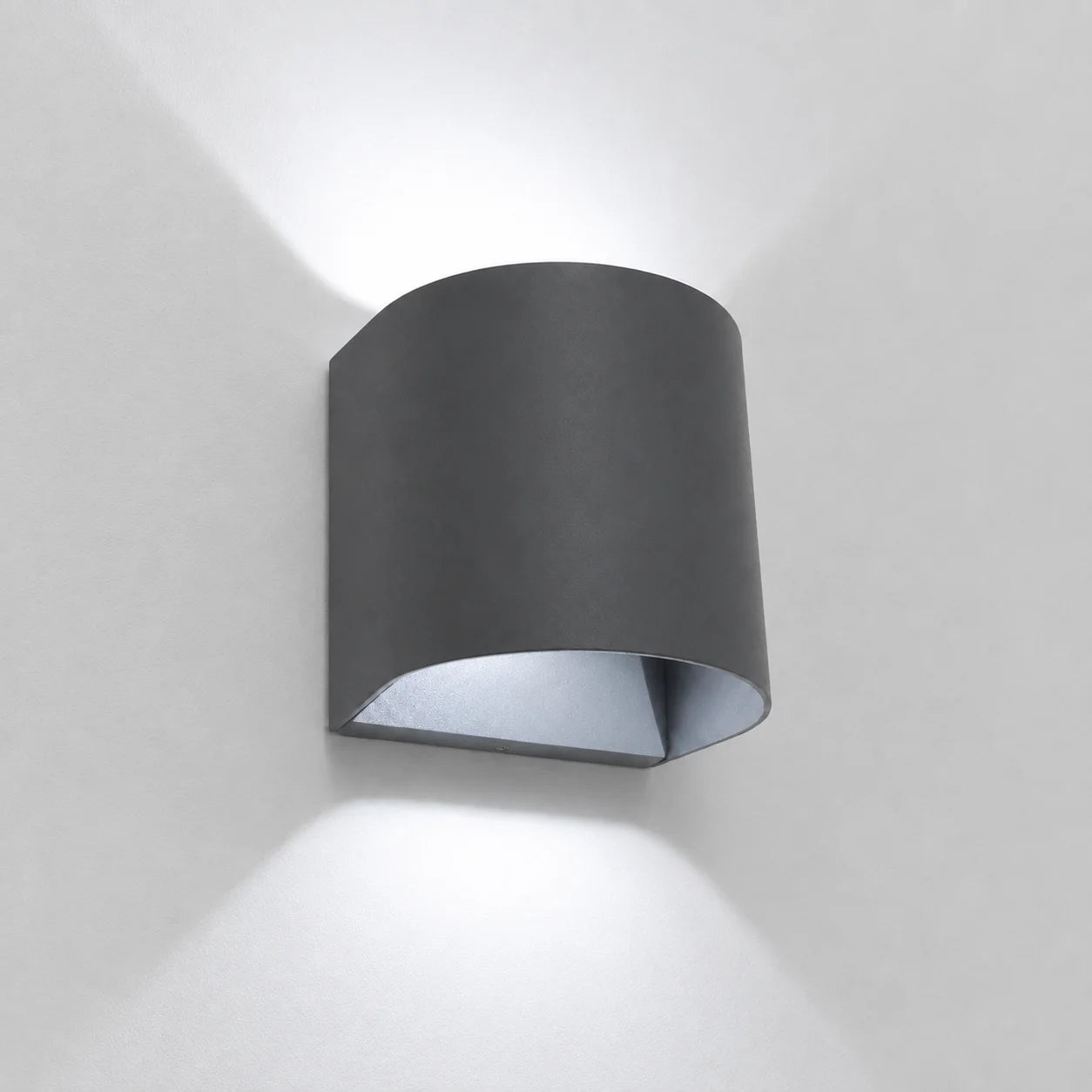Fischer LED Außenwandleuchte in Anthrazit an einer weißen Wand mit kaltweißem Up-&-Down-Lichteffekt.