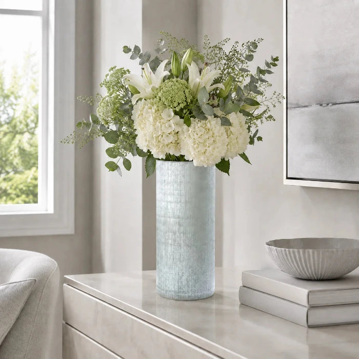 Graue Blumenvase Ashley aus strukturiertem Glas mit frischem Blumenstrauß auf einem Sideboard im modernen Wohnzimmer