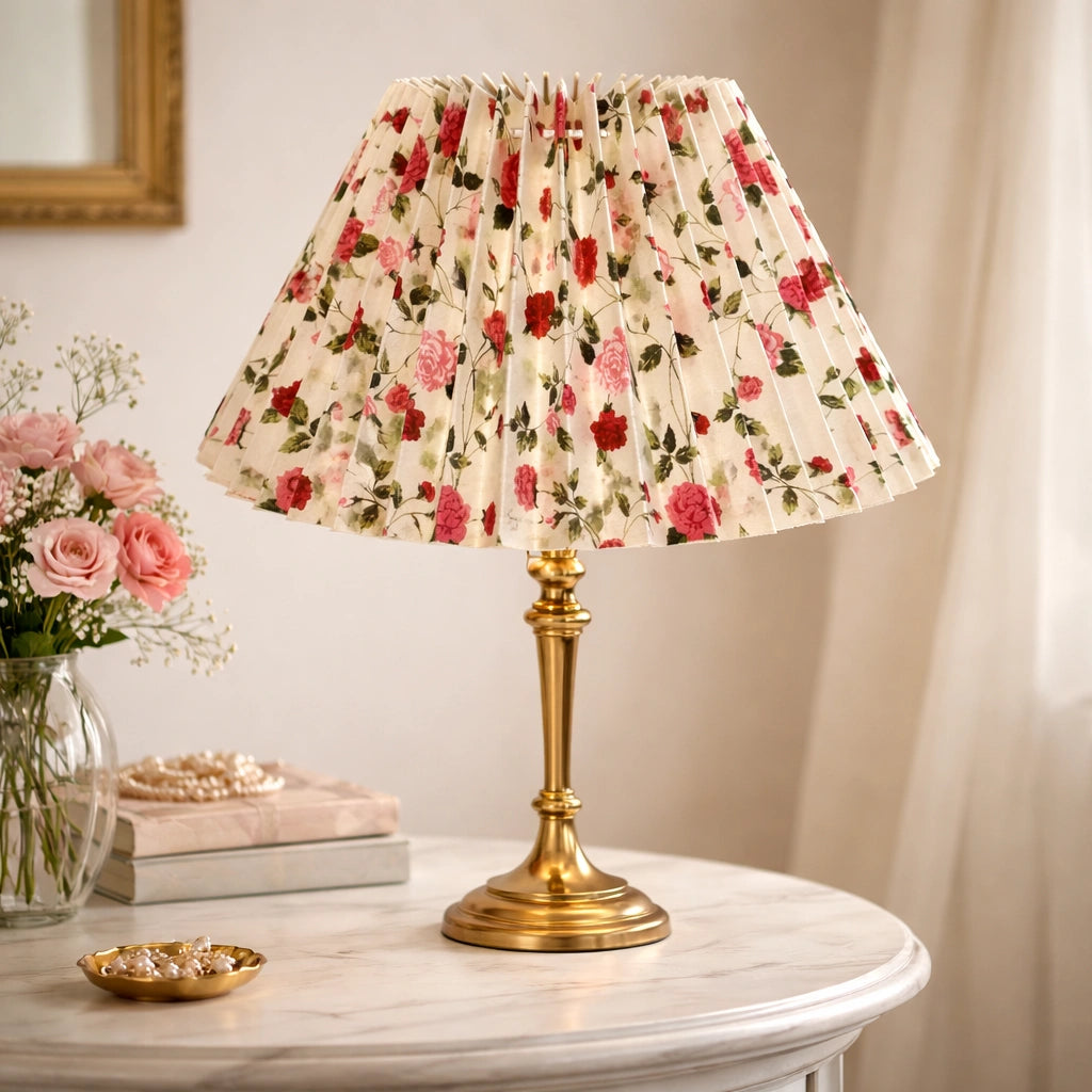 Weißer plissierter Lampenschirm mit floralem Rosenmuster auf goldener Tischlampe im Wohnraum