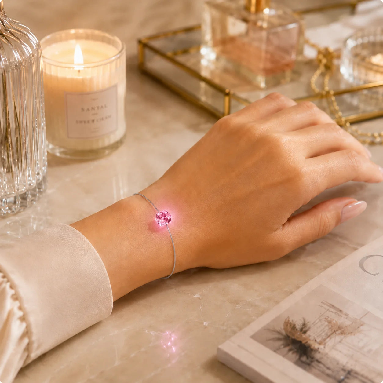 Leuchtendes LED Kristall Armband in Pink mit feinem grauem Edelstahlband am Handgelenk einer Frau.