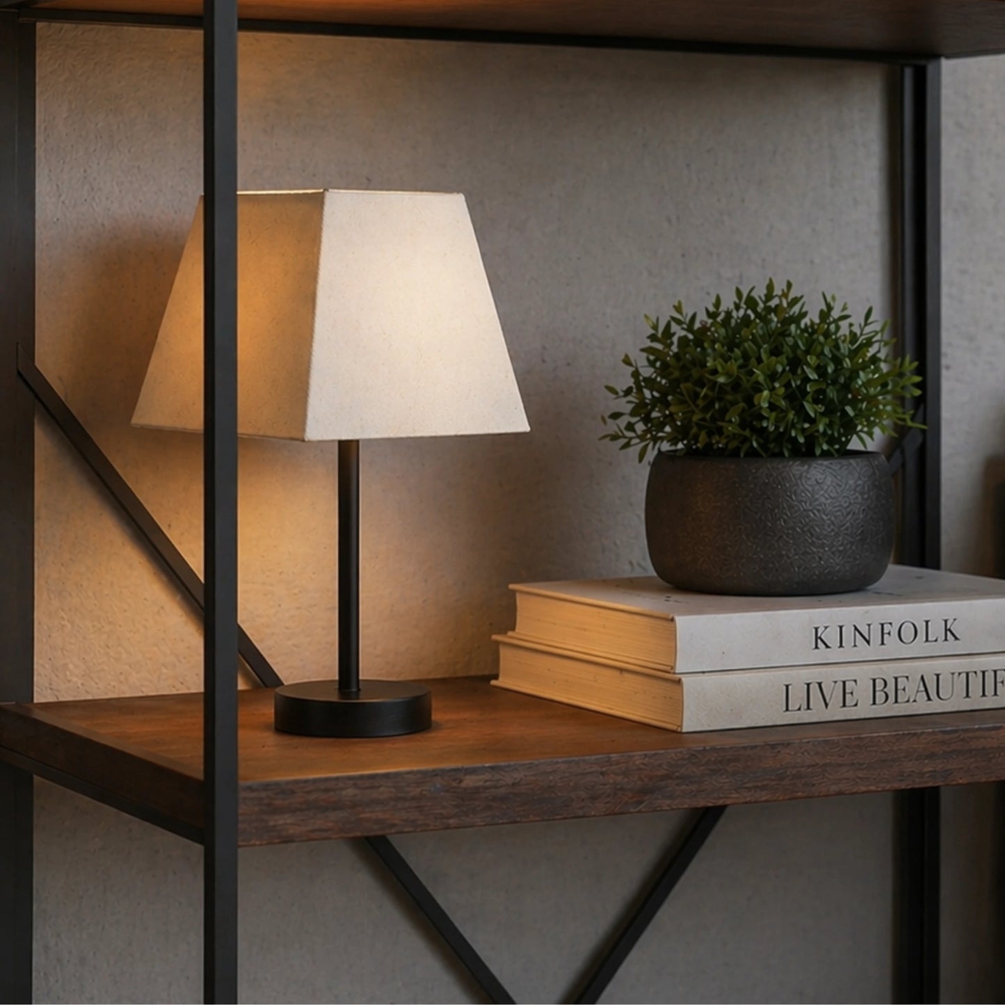 Quadratischer Lampenschirm in Creme auf schwarzer Tischlampe in modernem Wohnraum mit warmer Beleuchtung – Light & Living