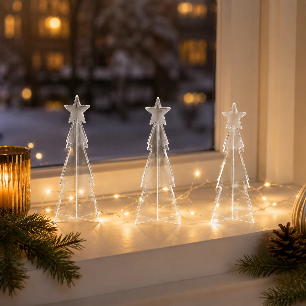 Drei klare Mini-Acryl-Tannenbäume als Weihnachtsdekoration.