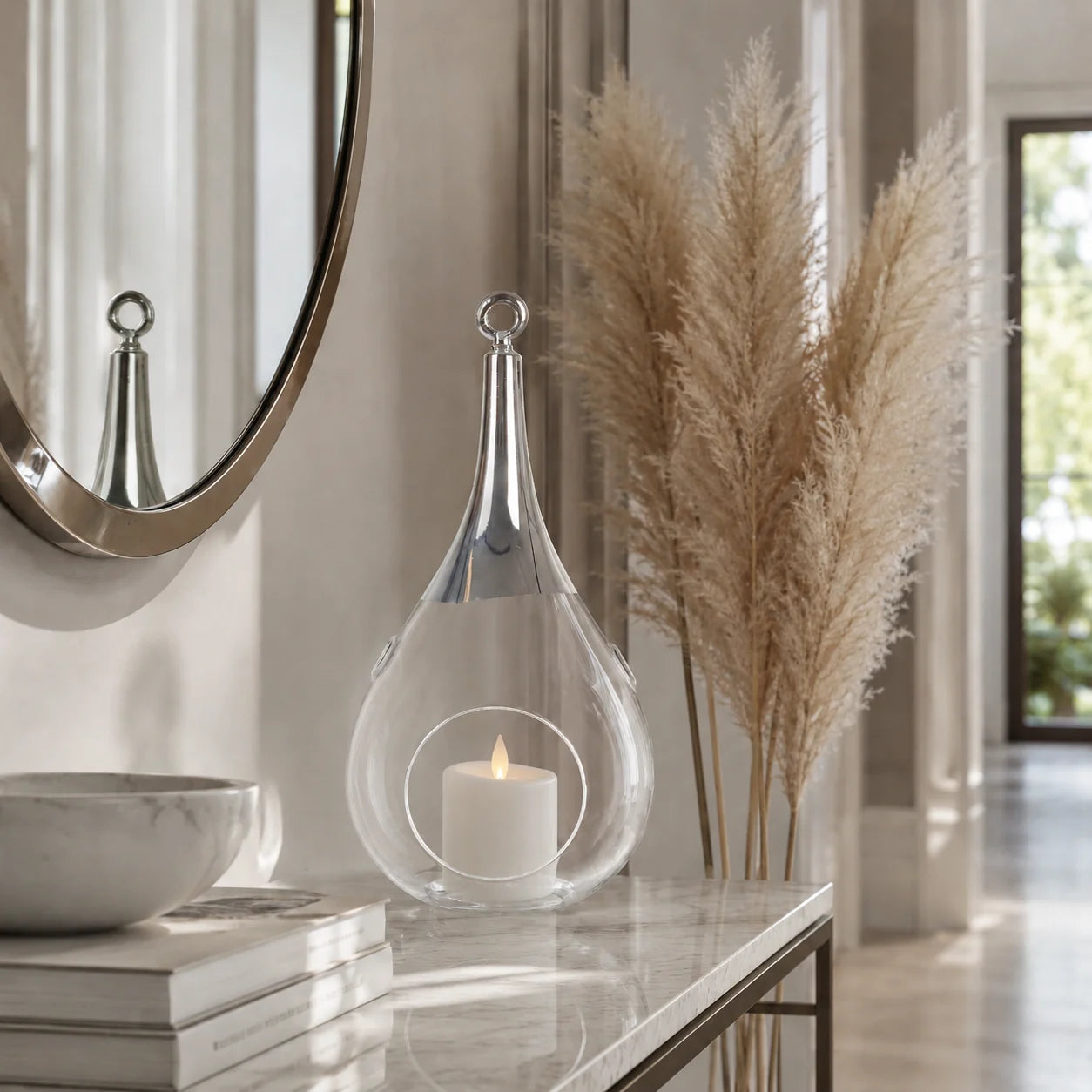 Sompex Taura Glas-Windlicht mit Chromabschluss und leuchtender Kerze als moderne Dekoration auf einer hellen Konsole