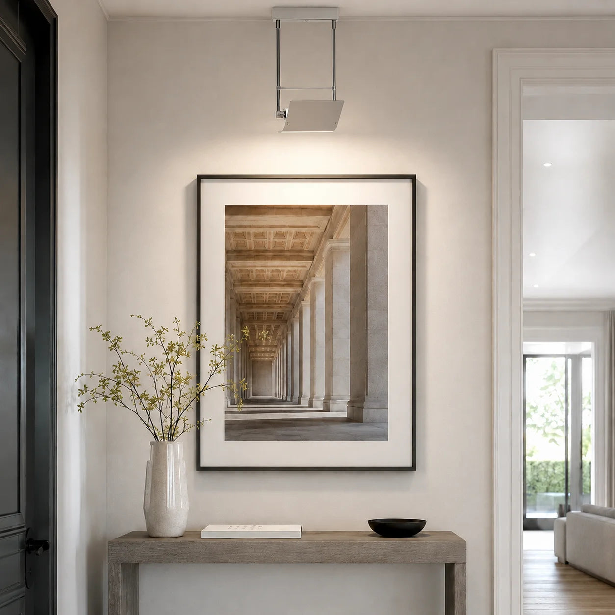 Rock 25 Decken- oder Wandleuchte in Nickel matt mit Segel-Reflektor als moderne Bildbeleuchtung im Flur über einem gerahmten Wandbild.