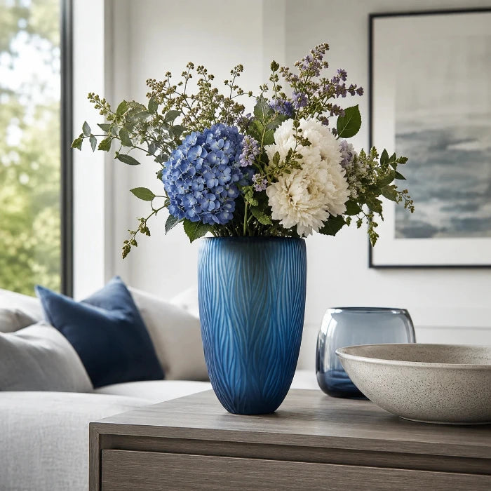 Blaue Glasvase Dinah mit frischem Blumenstrauß auf einem Sideboard in einem modernen Wohnzimmer