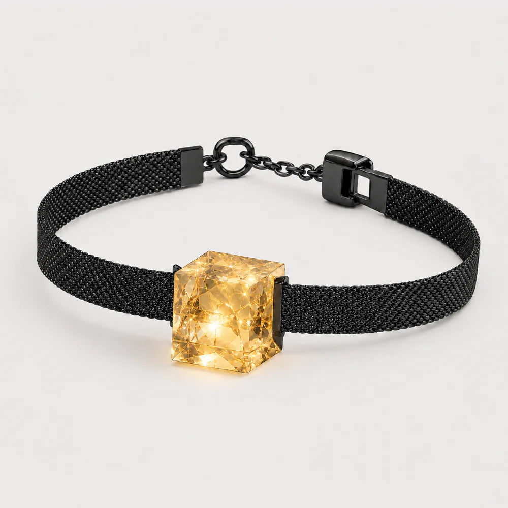 Schwarzes Armband mit feiner Struktur und gelbem facettiertem Kristallwürfel als Schmuckelement.