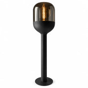 Sompex DOME Stehlampe 120 cm in Schwarz mit amberfarbenem mundgeblasenem Glas und warm leuchtendem Leuchtmittel vor weißem Hintergrund.