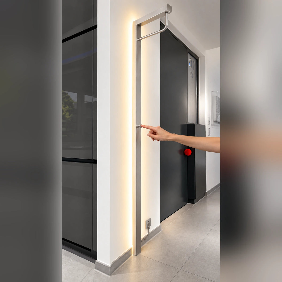 Hand bedient den runden Lichtschalter der beleuchteten Sompex Garderobe
