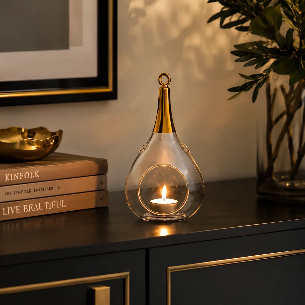 Sompex Taura Gold klein Windlicht auf einer Kommode im modernen Wohnzimmer mit brennendem Teelicht